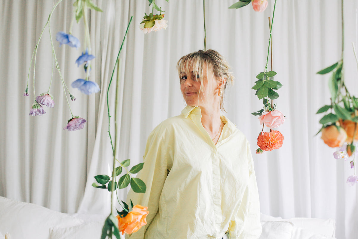 Abby stands amongst faux flowers Tussie